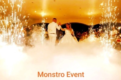 Un DJ mixant de la musique sur une table de mixage éclairée par des lumières colorées dans une ambiance nocturne.