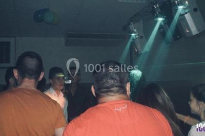 Table de mixage DJ avec platines lumineuses et un ordinateur portable affichant un logiciel de mixage.