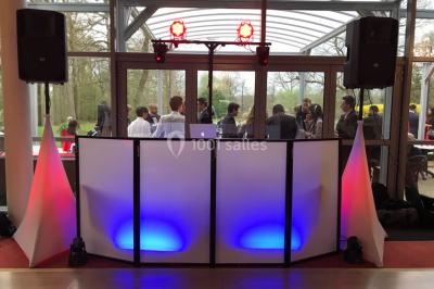 Miniature DJ Villiers-le-Bel (Val-d'Oise) - Gass Prod & Events #3 Console de DJ éclairée en bleu et rouge, installée dans une salle vitrée avec des invités en arrière-plan.