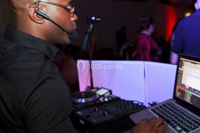 Miniature DJ Villiers-le-Bel (Val-d'Oise) - Gass Prod & Events #17 Salle de réception éclairée avec des lumières colorées, vue depuis une table de DJ équipée d'un ordinateur et de platines.