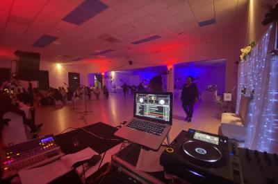 Miniature DJ Villiers-le-Bel (Val-d'Oise) - Gass Prod & Events #24 Salle de réception éclairée avec des lumières colorées, vue depuis une table de DJ équipée d'un ordinateur et de platines.