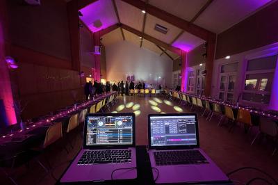 Miniature DJ Villiers-le-Bel (Val-d'Oise) - Gass Prod & Events #3 Salle de réception éclairée avec des lumières colorées, vue depuis une table de DJ équipée d'un ordinateur et de platines.