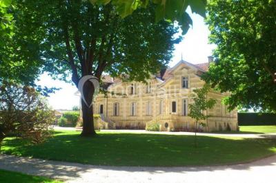 Table dressée avec des verres, tasses à café, un menu, un ordinateur portable ouvert et des chandeliers en arrière-plan.
