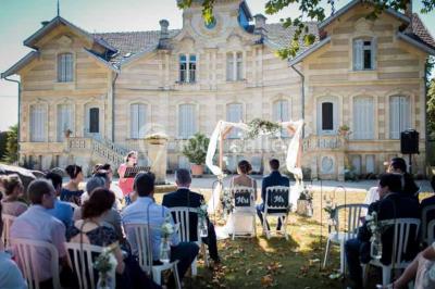 Table dressée avec des verres, tasses à café, un menu, un ordinateur portable ouvert et des chandeliers en arrière-plan.