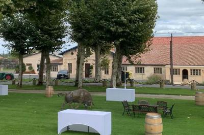Table dressée avec des verres, tasses à café, un menu, un ordinateur portable ouvert et des chandeliers en arrière-plan.