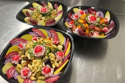 Miniature Traiteur Épinay-sur-Orge (Essonne) - Stevents Team Traiteur #31 Trois salades colorées présentées dans des bols noirs, composées de légumes variés et décorées de radis sculptés.