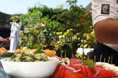 Fontaines de chocolat entourées de fruits frais, guimauves et brochettes sur une table de buffet.