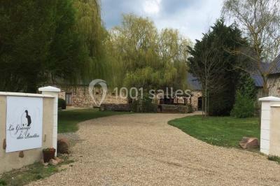 Texte ’Bienvenue à notre mariage’ écrit sur un miroir décoré de fleurs, reflétant un jardin verdoyant.