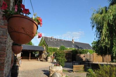 Texte ’Bienvenue à notre mariage’ écrit sur un miroir décoré de fleurs, reflétant un jardin verdoyant.