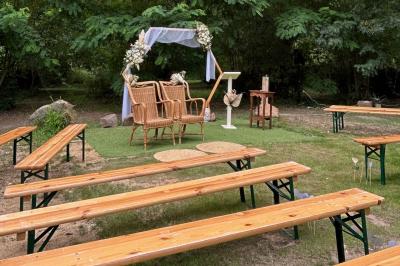 Texte ’Bienvenue à notre mariage’ écrit sur un miroir décoré de fleurs, reflétant un jardin verdoyant.