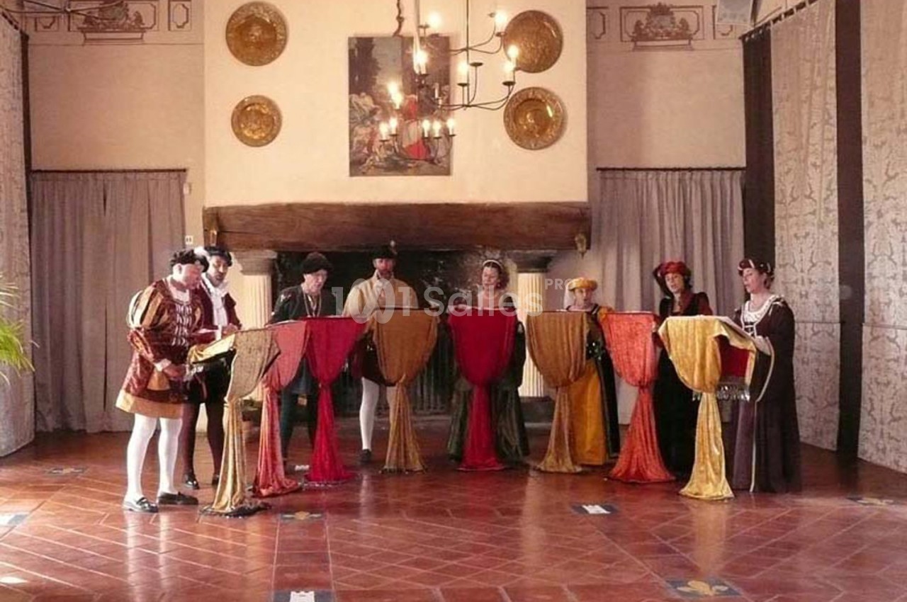 Des chanteurs en costumes d'époque interprètent devant des pupitres dans une salle décorée de style ancien.