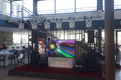 Salle de réception décorée avec des lumières colorées, des lanternes suspendues et un espace pour la musique et la danse.