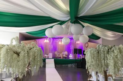 Miniature Arnal Décoration #3 Arc décoratif en fleurs blanches placé dans une salle avec des rideaux gris et un sol en béton.