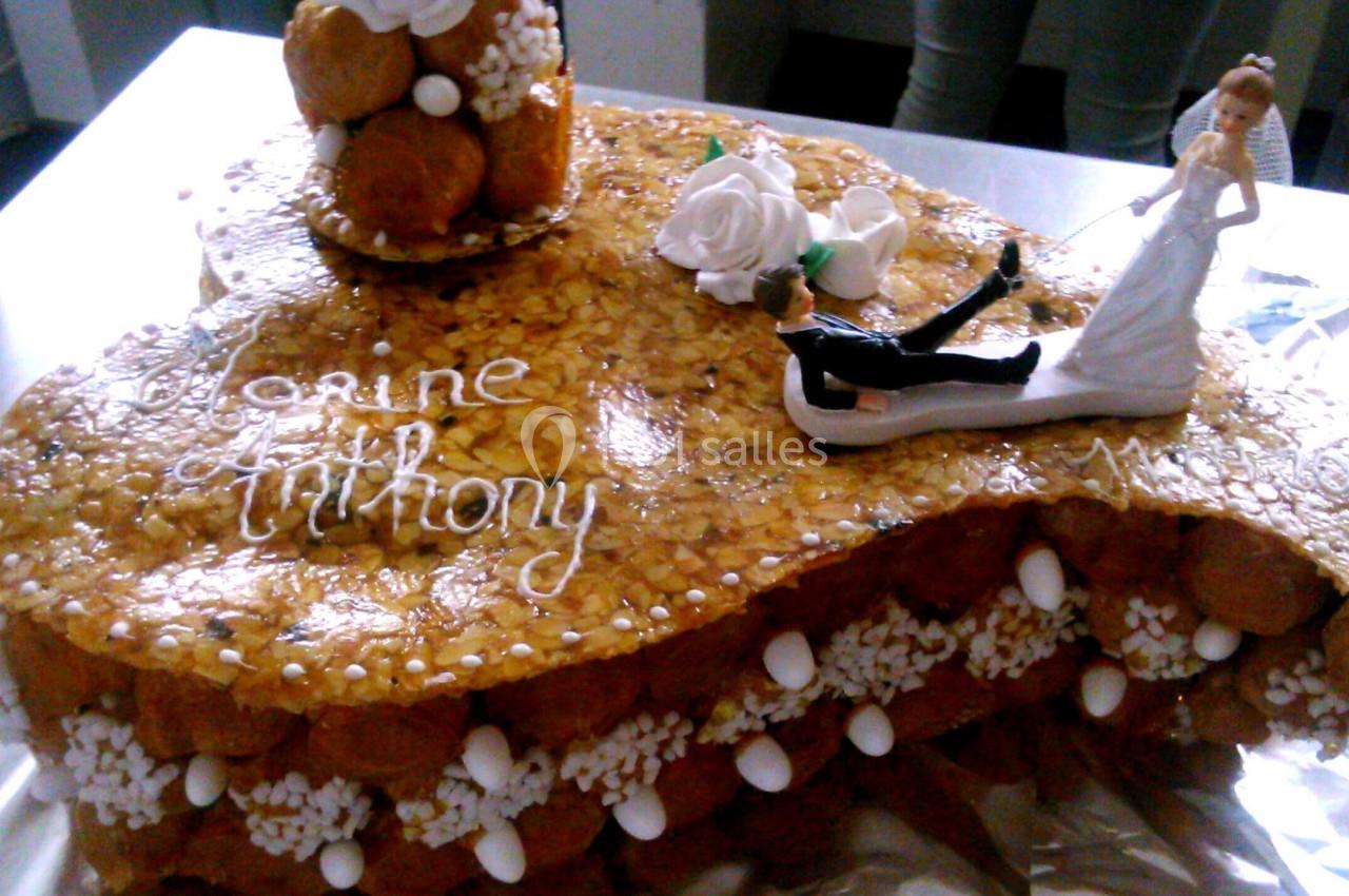 Pièce montée en choux caramélisés décorée de roses en sucre, d'une figurine de mariée et d'un message personnalisé.
