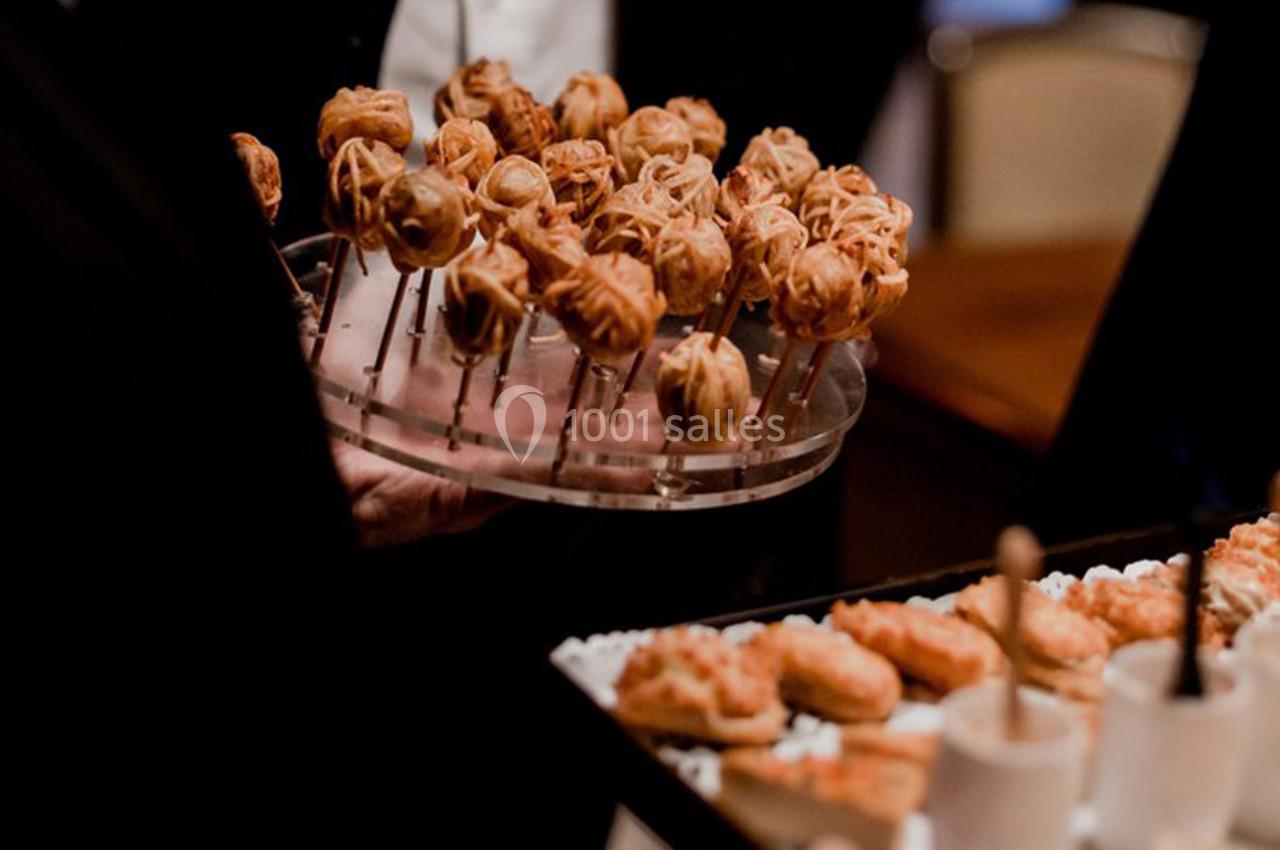 Plateaux de bouchées apéritives variées, comprenant des brochettes et des verrines, servis lors d'un événement.