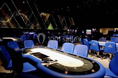 Salle de restaurant moderne avec des tables dressées, des chaises orange et un éclairage chaleureux.