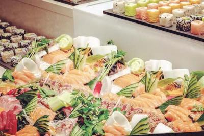 Salle de restaurant moderne avec des tables dressées, des chaises orange et un éclairage chaleureux.