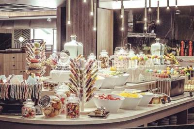 Salle de restaurant moderne avec des tables dressées, des chaises orange et un éclairage chaleureux.