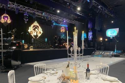 Salle de restaurant moderne avec des tables dressées, des chaises orange et un éclairage chaleureux.