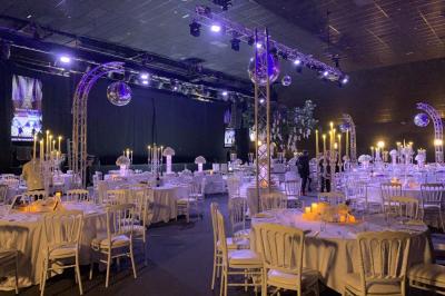 Salle de restaurant moderne avec des tables dressées, des chaises orange et un éclairage chaleureux.