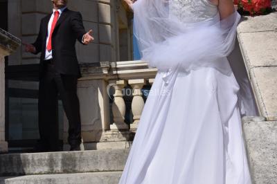 Miniature Claire Avias Créations #5 Mannequin vêtu d'une robe en dentelle blanche avec un voile noir couvrant la tête, devant une porte en bois clair.