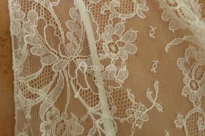 Miniature Claire Avias Créations #18 Mannequin vêtu d'une robe en dentelle blanche avec un voile noir couvrant la tête, devant une porte en bois clair.