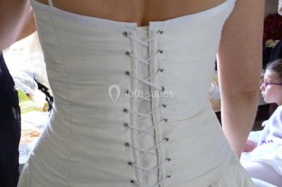 Miniature Claire Avias Créations #19 Mannequin vêtu d'une robe en dentelle blanche avec un voile noir couvrant la tête, devant une porte en bois clair.