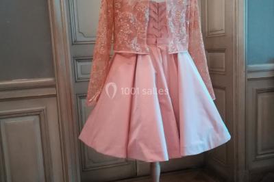 Miniature Claire Avias Créations #29 Mannequin vêtu d'une robe en dentelle blanche avec un voile noir couvrant la tête, devant une porte en bois clair.