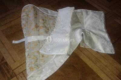 Miniature Claire Avias Créations #33 Mannequin vêtu d'une robe en dentelle blanche avec un voile noir couvrant la tête, devant une porte en bois clair.