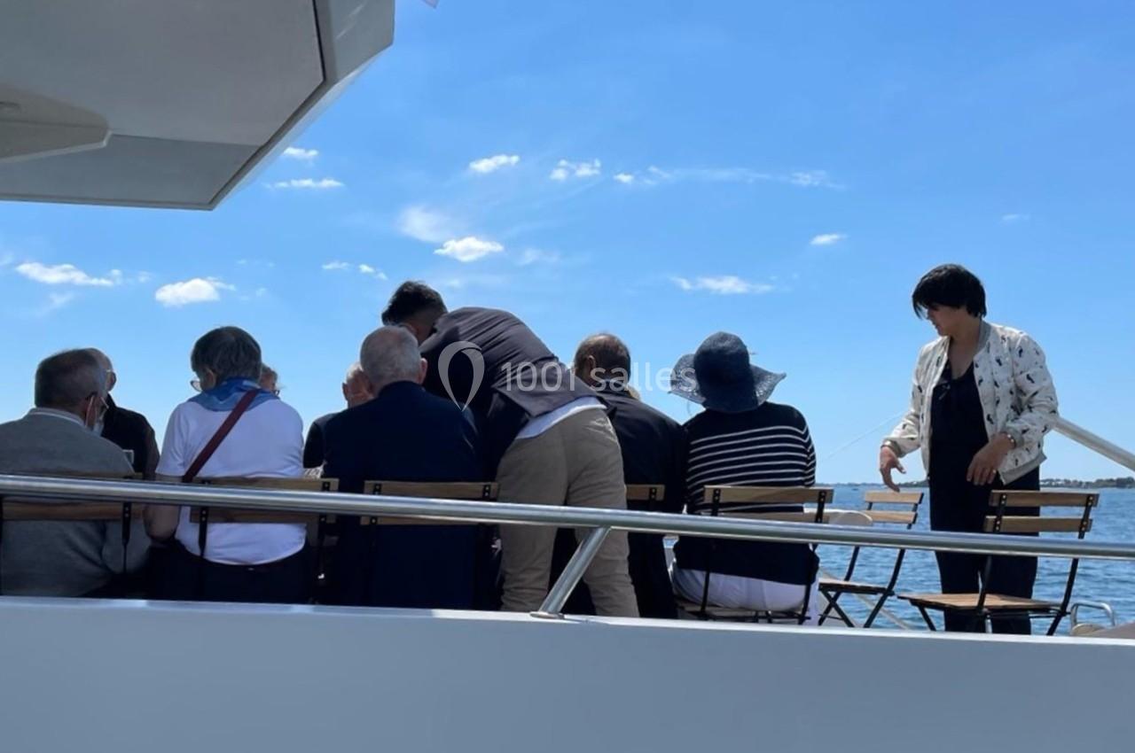 Un groupe de personnes assises à l'arrière d'un bateau, profitant d'une journée ensoleillée sur l'eau.