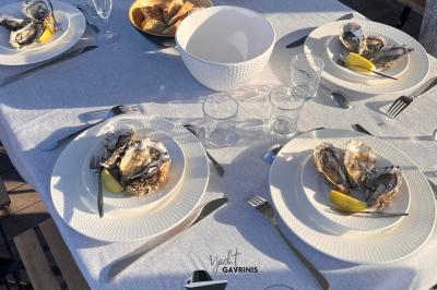 Mobilier en rotin noir avec coussins blancs sur une terrasse en bois couverte, vue sur l'extérieur urbain.
