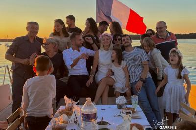 Mobilier en rotin noir avec coussins blancs sur une terrasse en bois couverte, vue sur l'extérieur urbain.