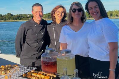 Mobilier en rotin noir avec coussins blancs sur une terrasse en bois couverte, vue sur l'extérieur urbain.