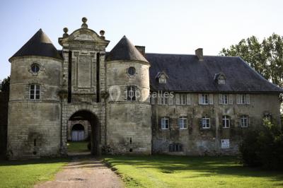 Miniature Façade avant du Château  Pièce rustique avec murs en pierre, plafond en bois, réservoir métallique rouge et mobilier simple.