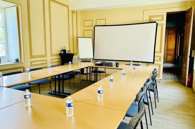 Miniature Les salons de Beaufremez ( version séminaire )  Pièce rustique avec murs en pierre, plafond en bois, réservoir métallique rouge et mobilier simple.