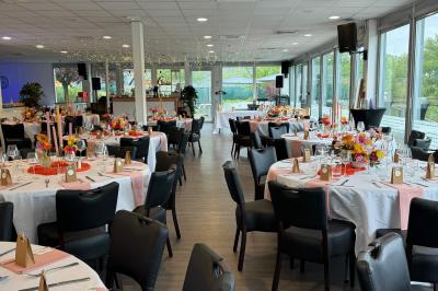 Miniature Location salle Bonneuil-sur-Marne (Val-de-Marne) - La Caravelle #2 Centre de table avec bougies torsadées, fleurs colorées et nappe orange, entouré de verres et couverts.