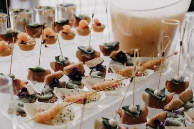 Miniature Location salle Bonneuil-sur-Marne (Val-de-Marne) - La Caravelle #21 Centre de table avec bougies torsadées, fleurs colorées et nappe orange, entouré de verres et couverts.