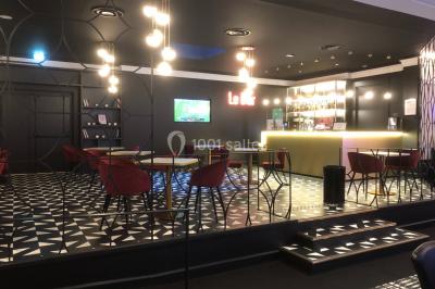 Main empilant des jetons de casino colorés sur une table, avec un arrière-plan flou de lumières et de jeux.