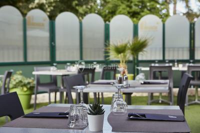 Main empilant des jetons de casino colorés sur une table, avec un arrière-plan flou de lumières et de jeux.