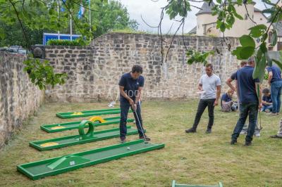 Un groupe de personnes en tenue formelle pose sur une scène lors d'un événement avec un écran affichant des logos en arrière…
