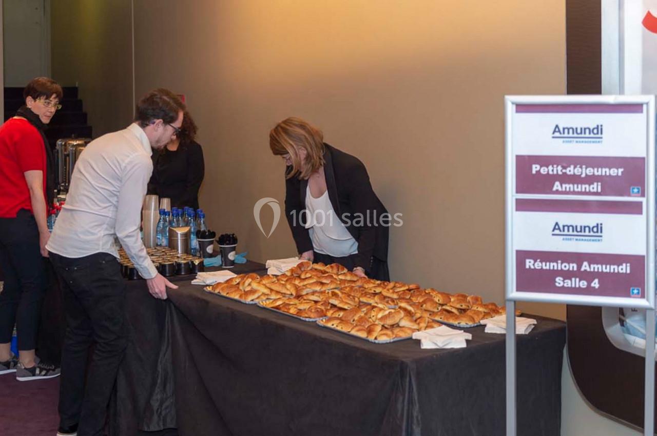 Table avec viennoiseries, boissons et panneaux indiquant ’Petit-déjeuner Amundi’ et ’Réunion Amundi Salle 4’.