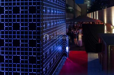 Un groupe de personnes en tenue formelle pose sur une scène lors d'un événement avec un écran affichant des logos en arrière…