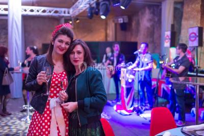 Un groupe de personnes en tenue formelle pose sur une scène lors d'un événement avec un écran affichant des logos en arrière…