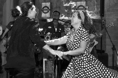 Un groupe de personnes en tenue formelle pose sur une scène lors d'un événement avec un écran affichant des logos en arrière…