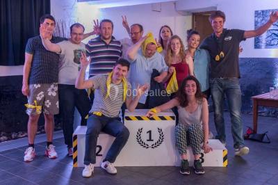 Un groupe de personnes en tenue formelle pose sur une scène lors d'un événement avec un écran affichant des logos en arrière…