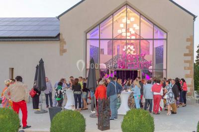 Un groupe de personnes en tenue formelle pose sur une scène lors d'un événement avec un écran affichant des logos en arrière…