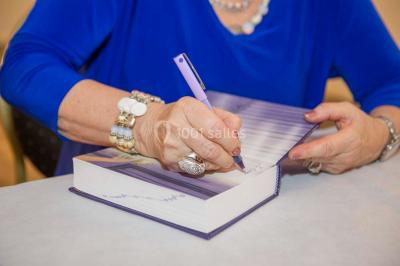 Un groupe de personnes en tenue formelle pose sur une scène lors d'un événement avec un écran affichant des logos en arrière…