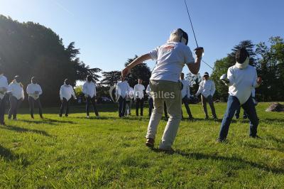 Un groupe de personnes souriantes pose dans une salle avec des rameurs et un écran projeté en arrière-plan.