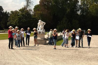 Un groupe de personnes souriantes pose dans une salle avec des rameurs et un écran projeté en arrière-plan.