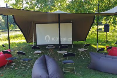 Un groupe de personnes souriantes pose dans une salle avec des rameurs et un écran projeté en arrière-plan.